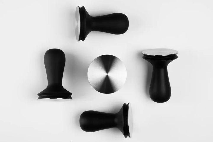 Barista Hustle 58.4mm coffee tamper alongside other Barista Hustle barista accessories