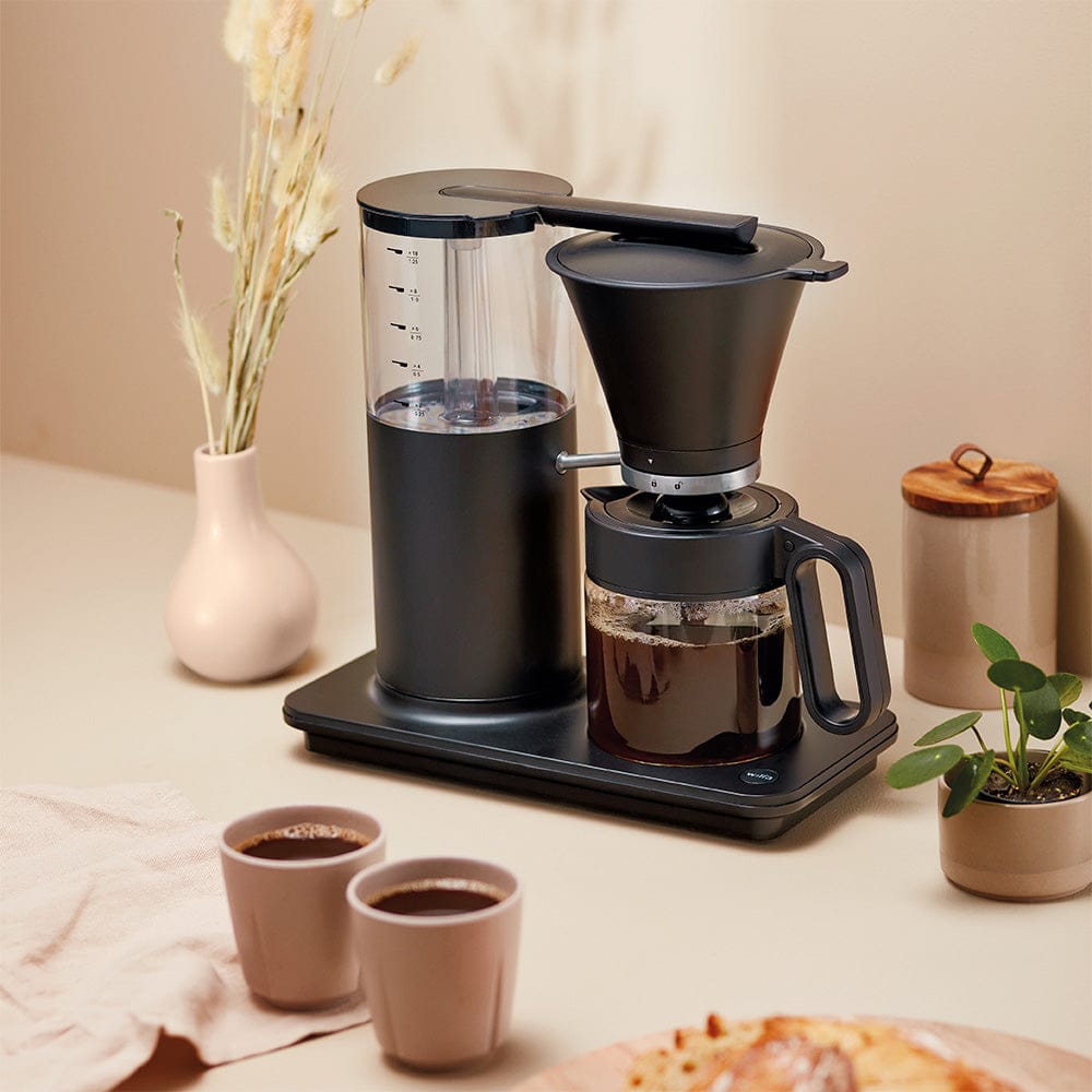 Wilfa Classic Tall Coffee Maker in Black with two cups on a table with decorative items