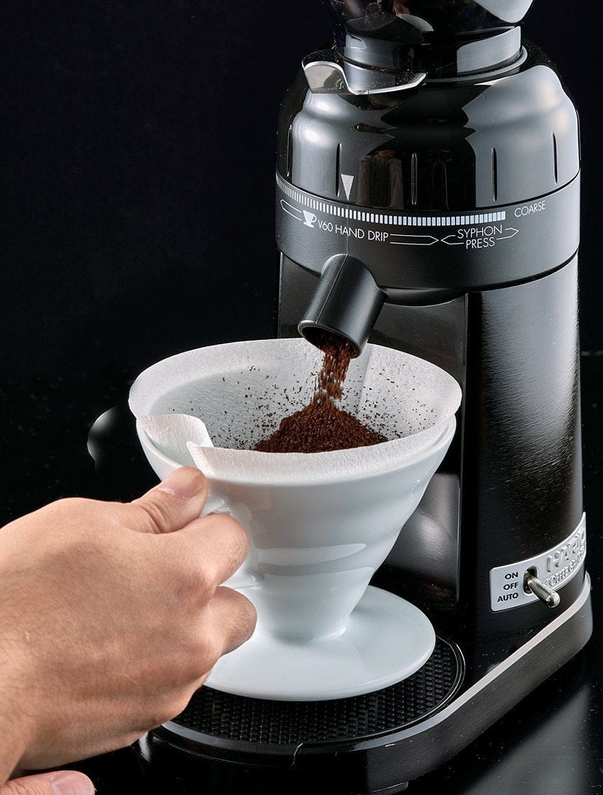 Hario V60 Electric Coffee Grinder with a white pour-over coffee filter being used to brew coffee.