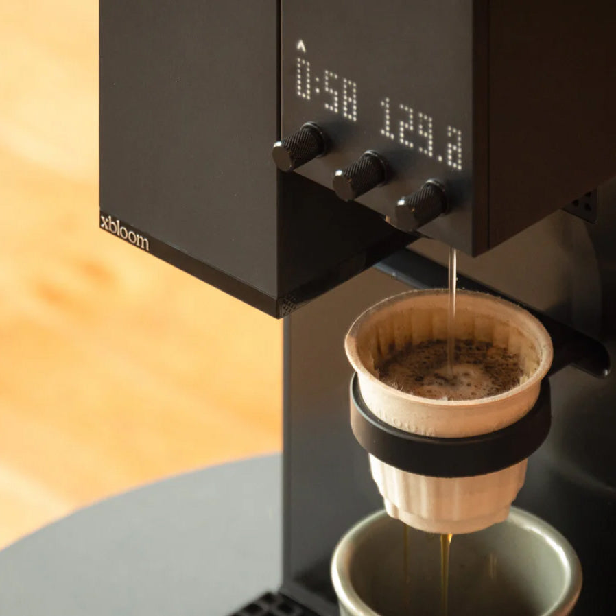 Midnight Black XBloom Studio Coffee Machine with a digital display and coffee filter on a wooden surface.