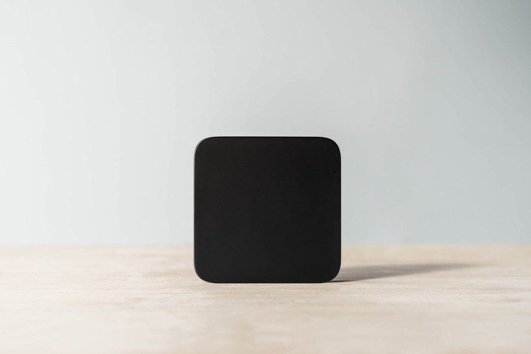 Acaia Umbra Lunar display-free coffee scale standing upright on a wooden counter