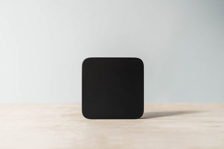 Acaia Umbra Lunar display-free coffee scale standing upright on a wooden counter
