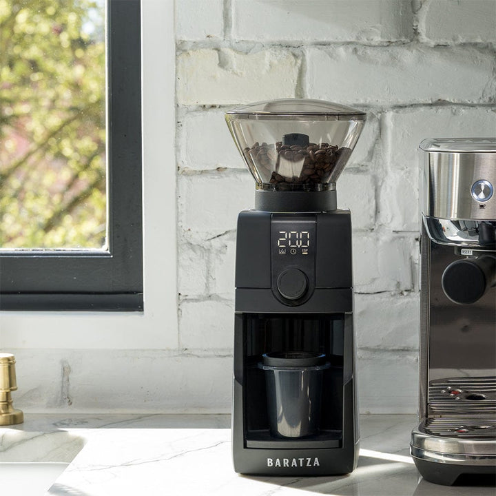 Baratza Encore ESP Pro Electric Coffee Grinder on a kitchen work top next to a coffee machine