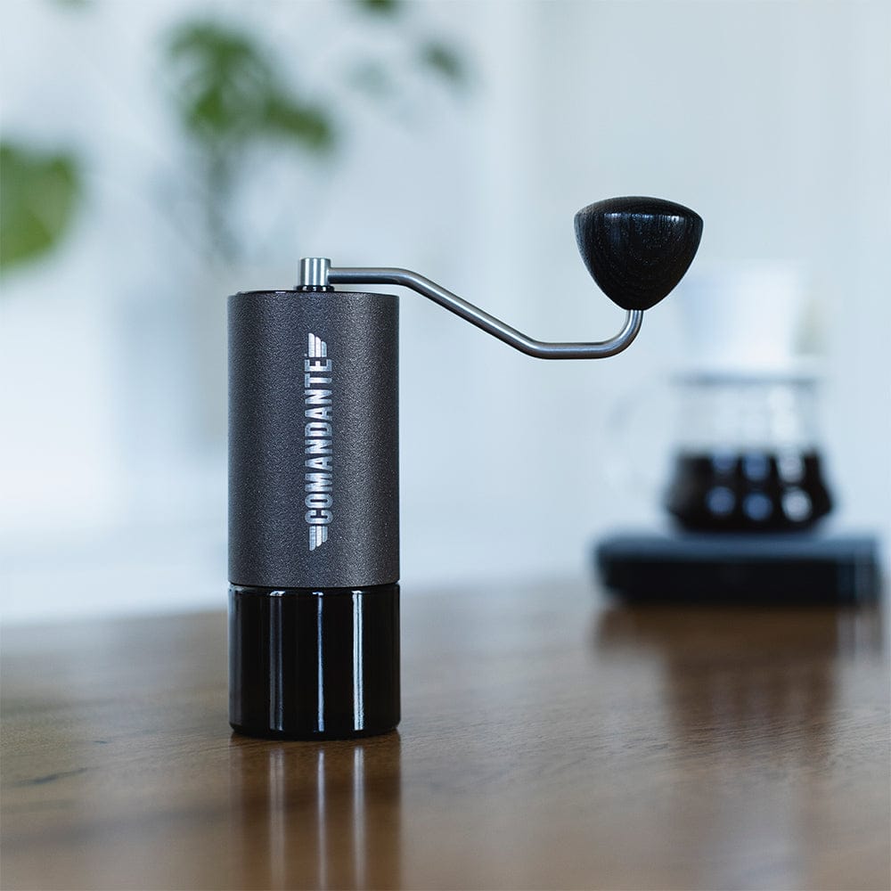 Comandante C40 Nitro Blade Coffee Grinder MK4 in Copper Mountain on a wooden surface with a blurred background