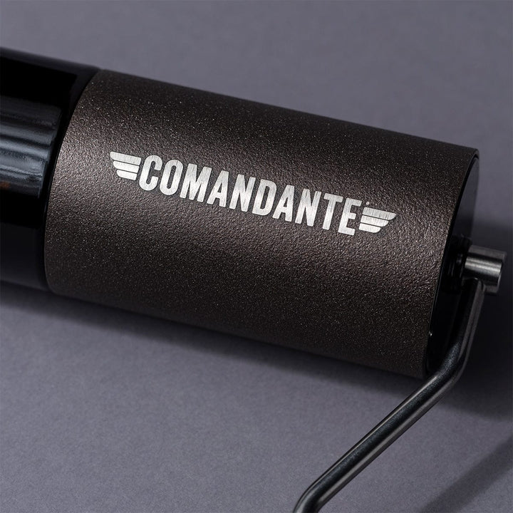 Close up of a Comandante C40 Nitro Blade Coffee Grinder MK4 in Copper Mountain with 'Comandante' branding on a grey background