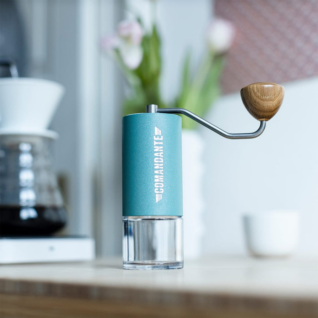 Comandante C40 Nitro Blade Coffee Grinder MK4 in Alpine Lagoon on a kitchen counter with a blurred background