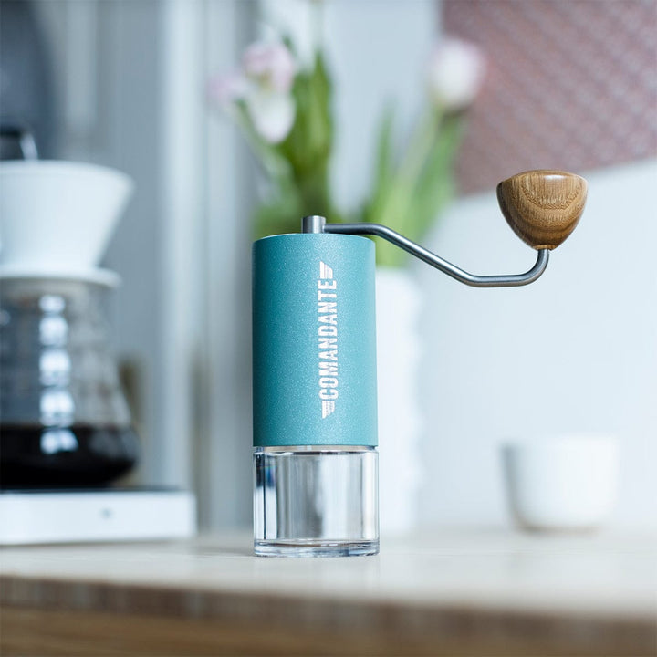 Comandante C40 Nitro Blade Coffee Grinder MK4 in Alpine Lagoon on a kitchen counter with a blurred background