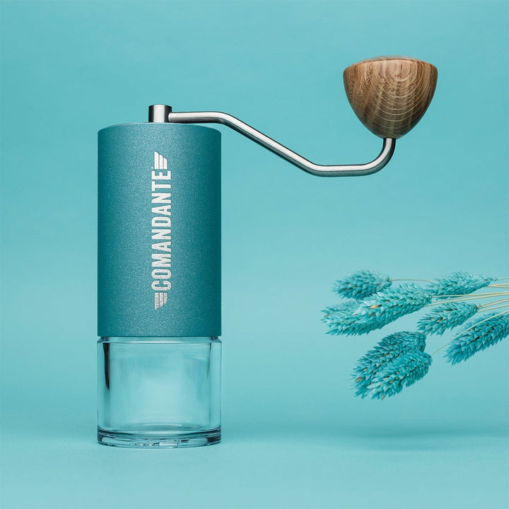 Comandante C40 Nitro Blade Coffee Grinder MK4 in Alpine Lagoon with wooden handle on a teal background