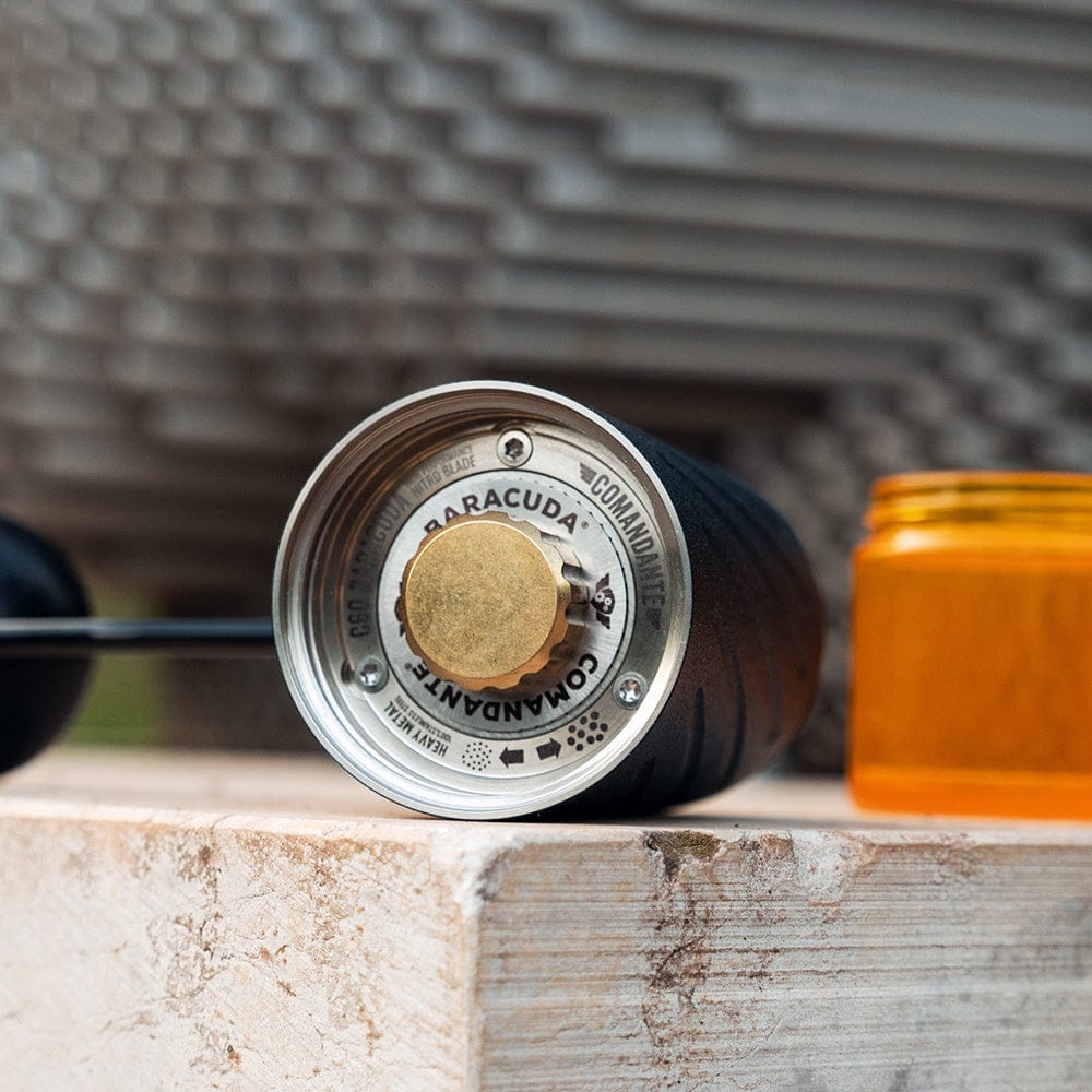 Comandante C60 Baracuda Coffee Grinder in Nautilus Blue on a stone surface with a blurred background