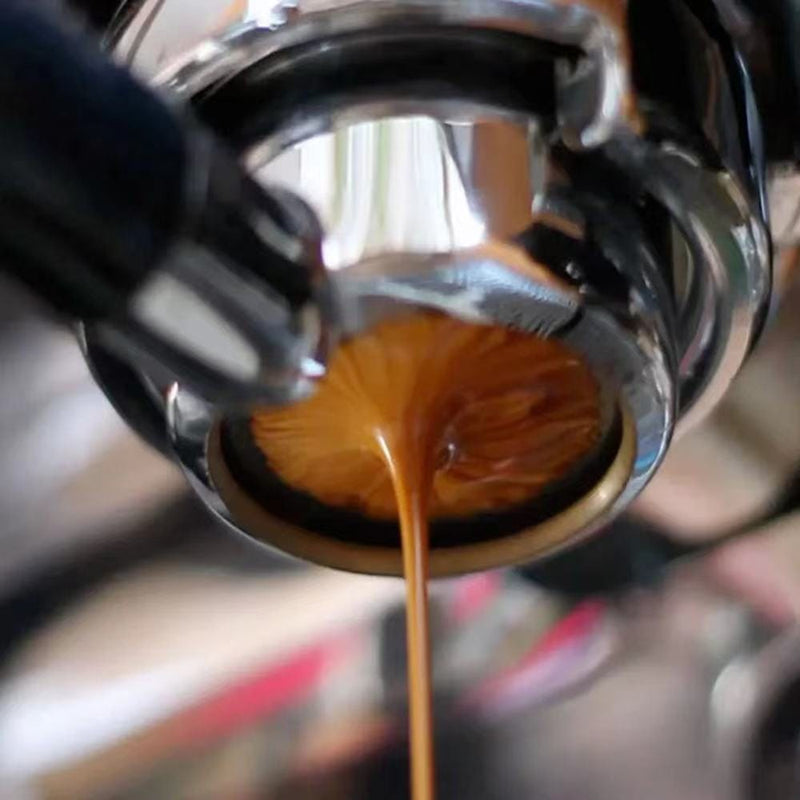Espresso shot pouring from portafilter, coffee bean blend.