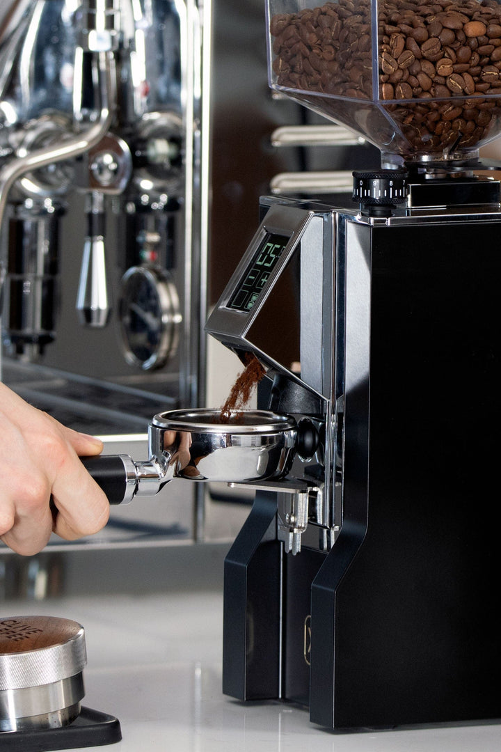Eureka Mignon XL grinding espresso into a portafilter held in the fork
