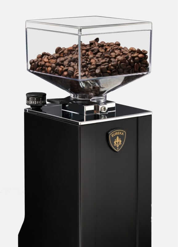Eureka Oro Mignon XL 65 Coffee Grinder in Black with a clear hopper filled with coffee beans on a white background