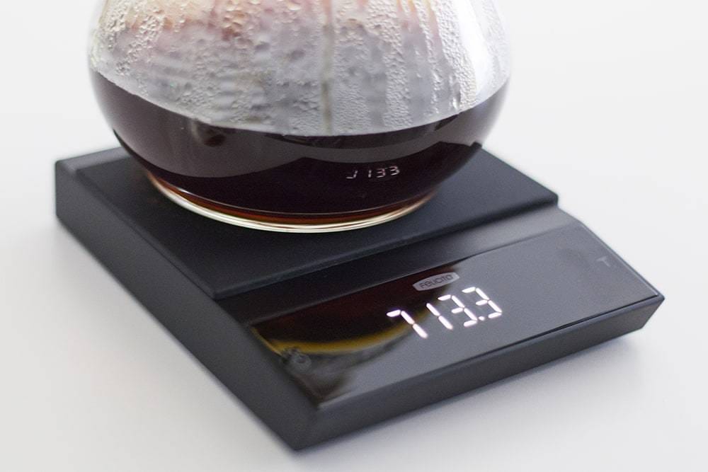 Coffee brewing carafe on a Felicita Incline Coffee Scale with a white background