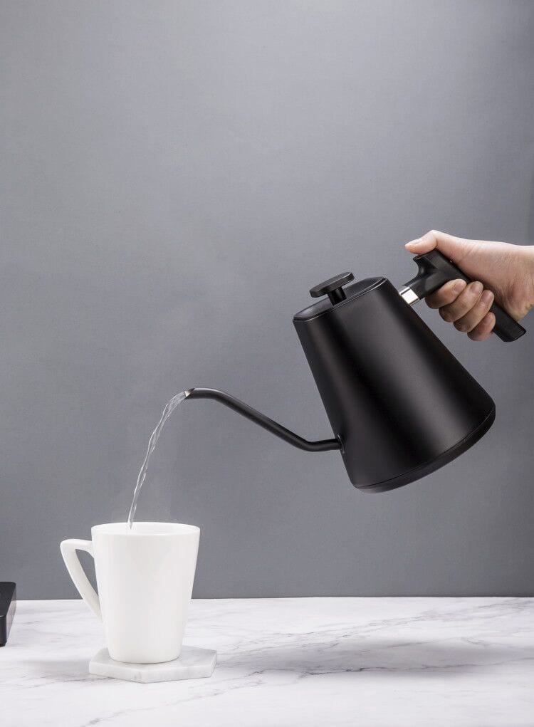 Felicita Square Temperature Control Electric Kettle being used to pour water into a white mug on a grey background