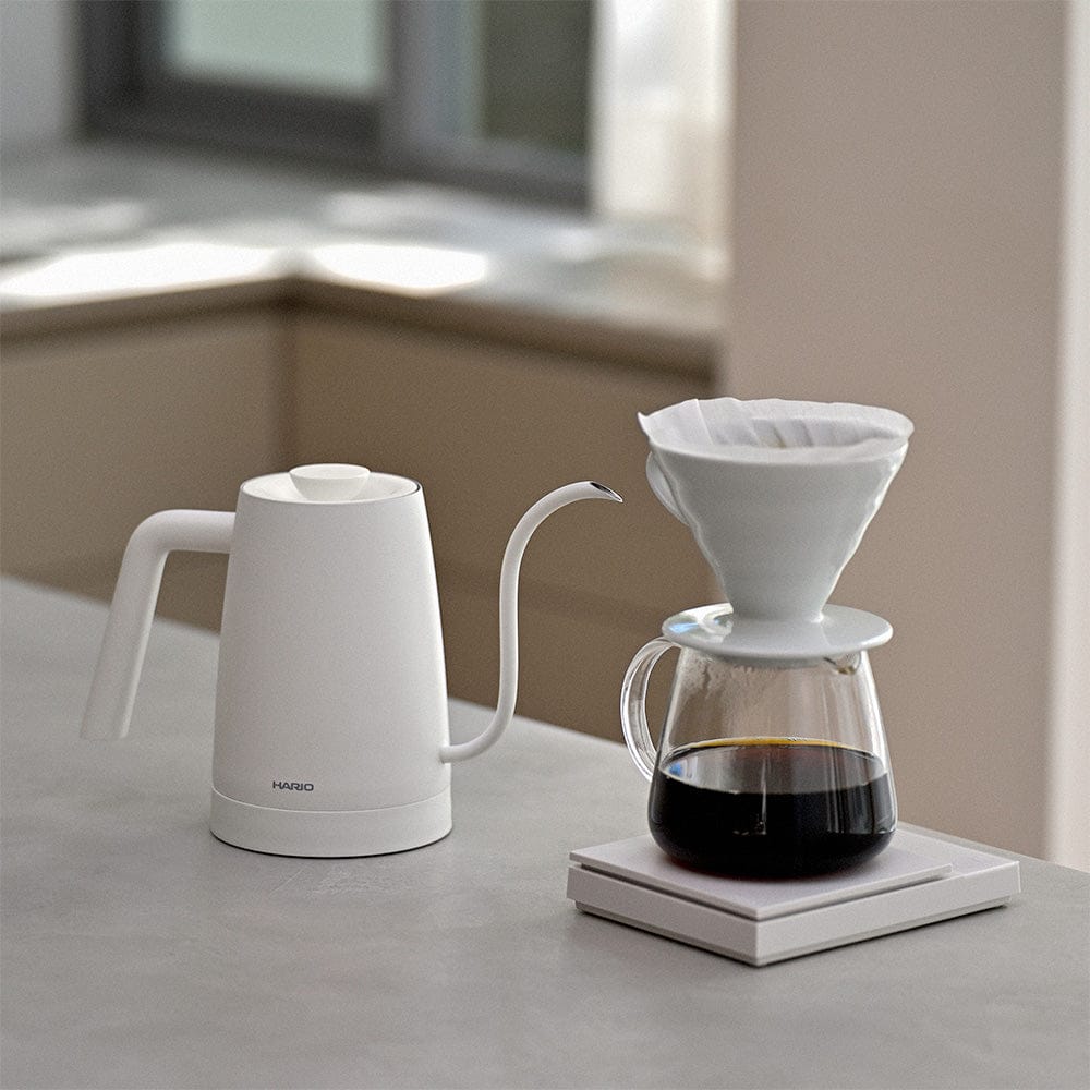 White Hario Lyra electric kettle and coffee maker on a kitchen counter.