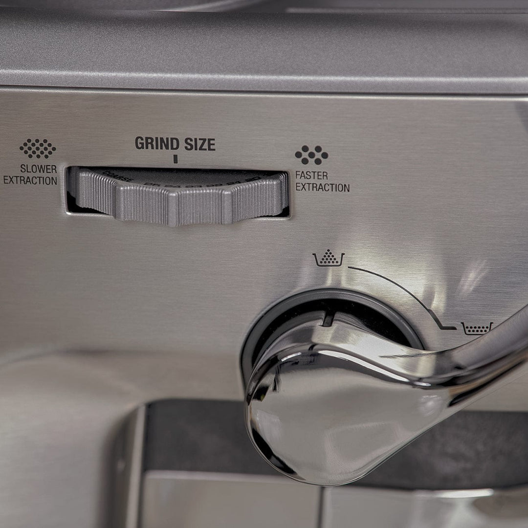 Close-up of a Stainless steel Sage Barista Express Impress Espresso Machine grind size dial and lever.