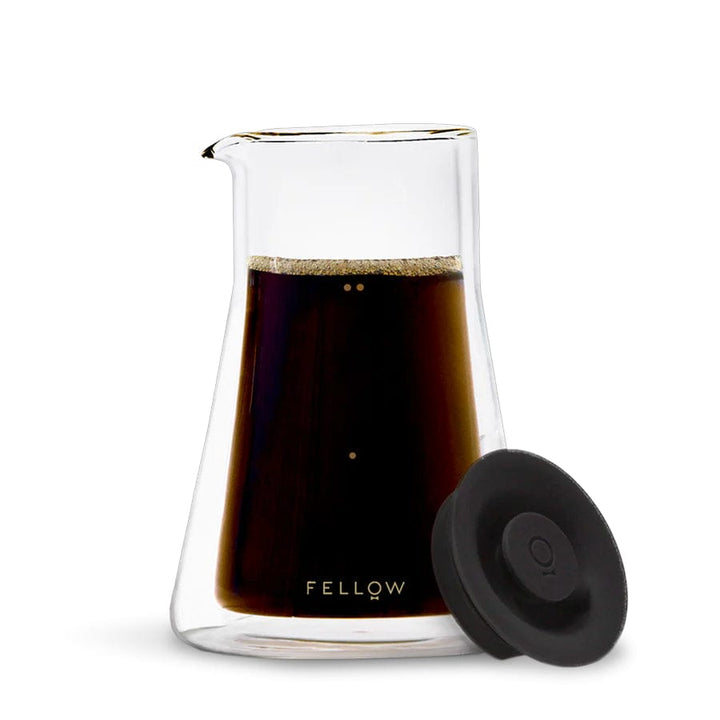 Fellow Stagg Double Wall Glass Carafe with black lid and coffee inside on a white background, featuring the 'Fellow' brand.