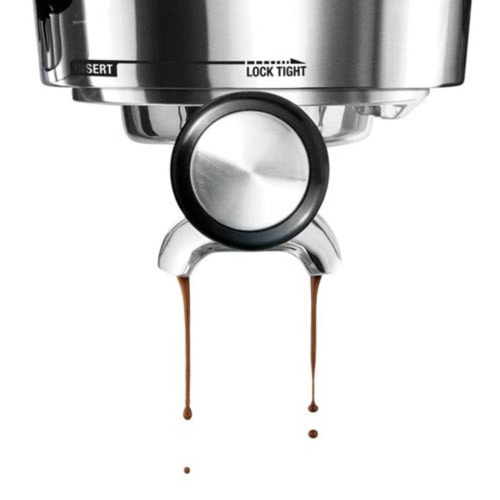The Sage Dual Boiler Black Truffle Espresso Coffee Machine group head with coffee dripping onto a white background